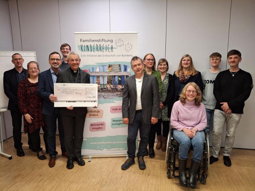Der ehemalige Erzbischof Dr. Ludwig Schick (5. v. li.) überbrachte Michael Endres (li. daneben) sowie VertreterInnen der Caritas aus der gesamten Erzdiözese einen Scheck der Stiftung Kinderreich.