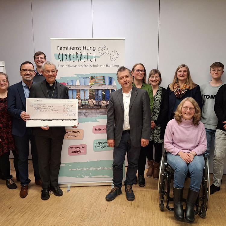 Der ehemalige Erzbischof Dr. Ludwig Schick (5. v. li.) überbrachte Michael Endres (li. daneben) sowie VertreterInnen der Caritas aus der gesamten Erzdiözese einen Scheck der Stiftung Kinderreich.