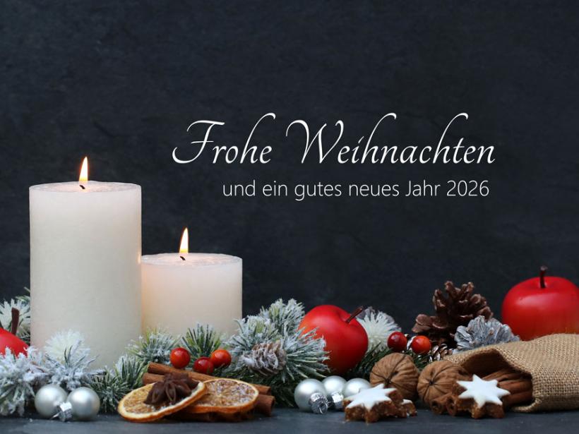 Das Weihnachtsmotiv zeigt zwei brennende Kerzen und Weihnachtsschmuck